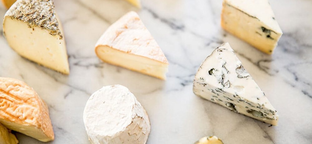 several different types of cheese on a marble board