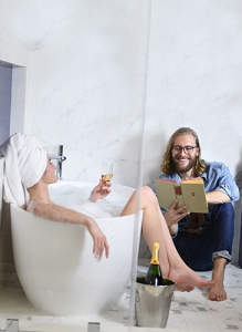 man reading to woman in a bathtub