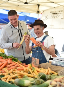 Jason Prendergast talking to a farmer holding carrots