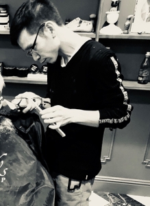 black and white photo of barber cutting hair