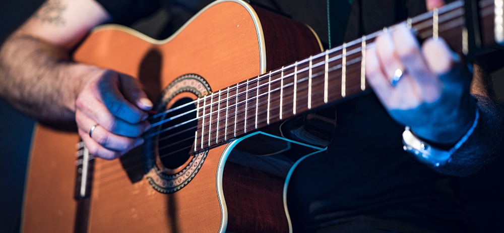 close up of a person playing guitar