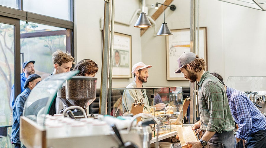 barista serves a customer at a coffee shop counter