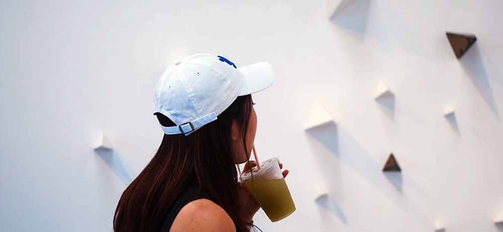 girl drinking an ice coffee looking at artwork