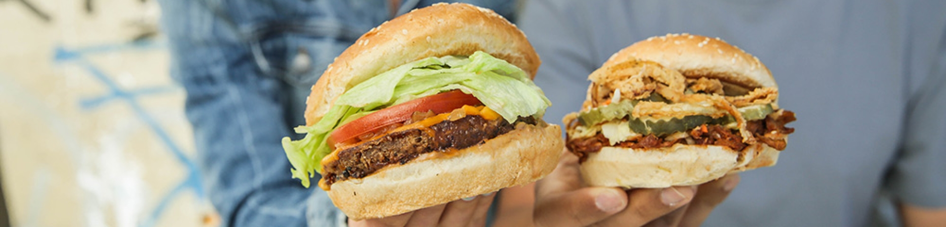 two people holding hamburgers