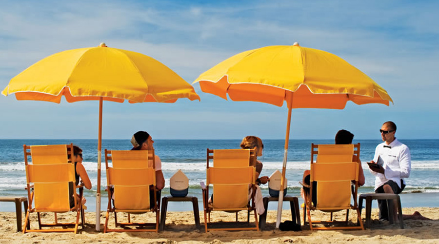 group sitting under yellow umbrellas at the beach