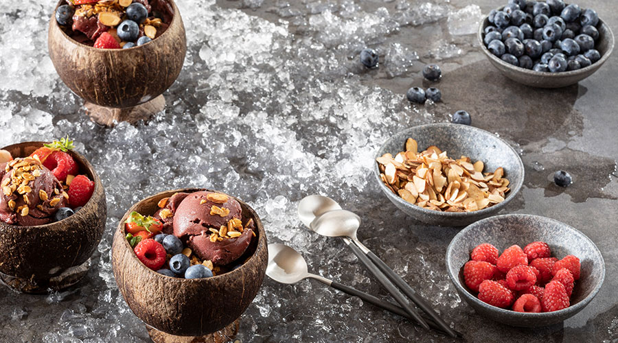 acai bowls on a table covered in crushed ice