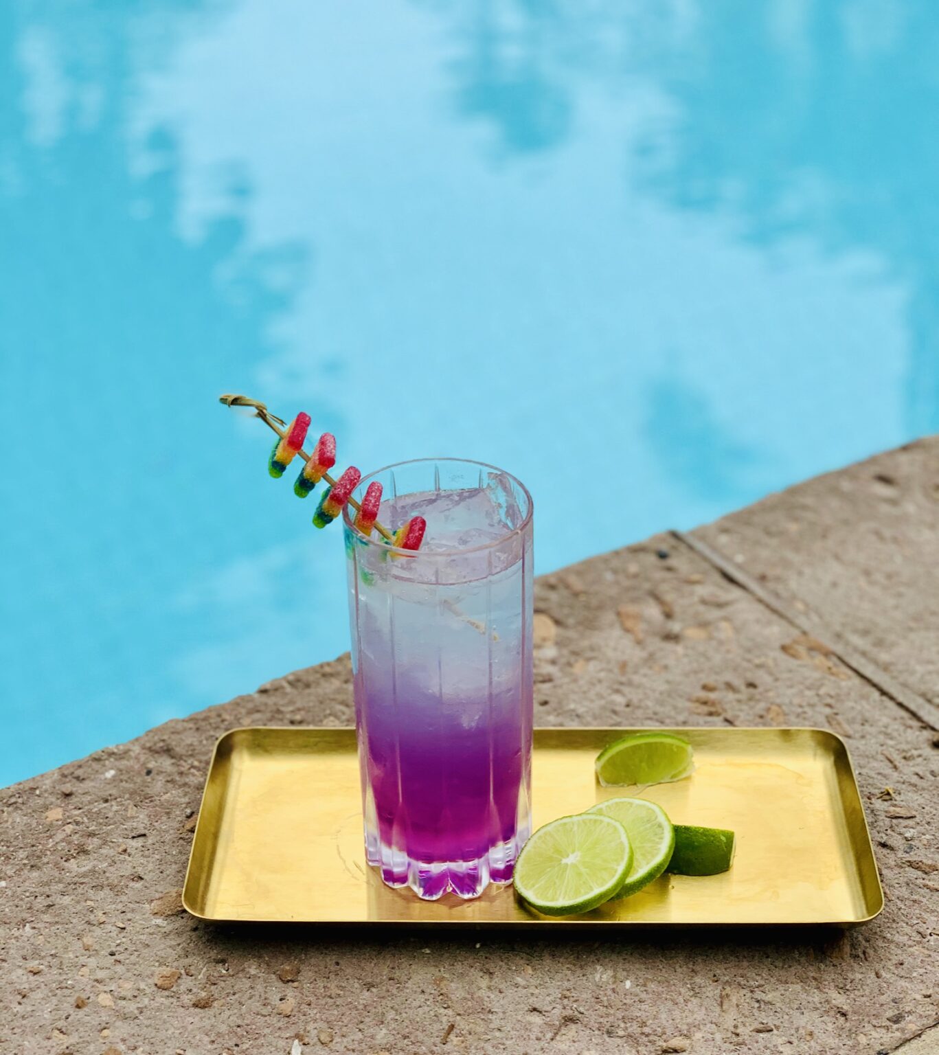 purple cocktail on the side of a pool