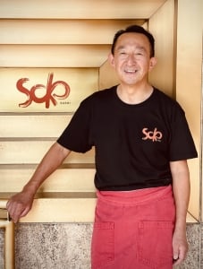 Chef Masa Shimakawa standing in front of SOKO sign