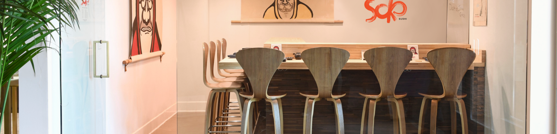 wooden stools around a sushi bar