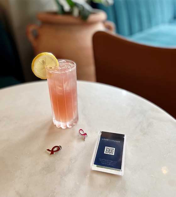 cocktail and breast cancer awareness ribbon pins on a table