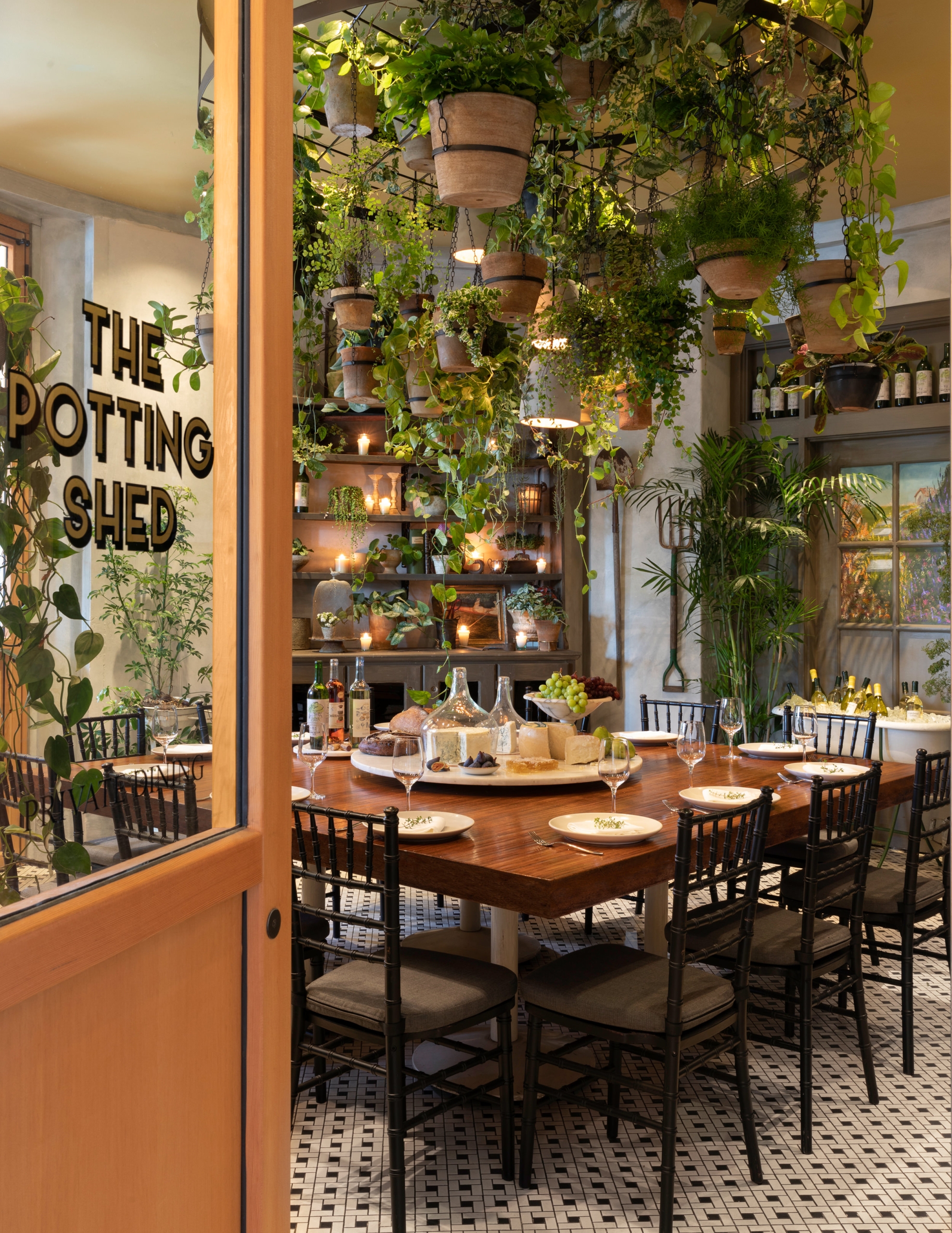 Banquet table with large amounts of foliage and plants on the walls nearby