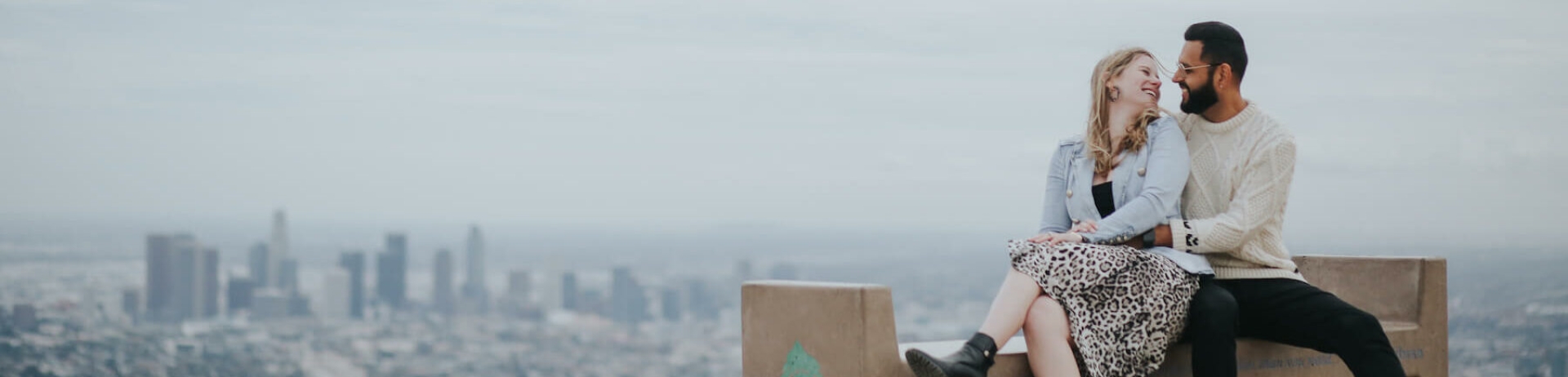 couple sitting on bench overlooking downtown Los Angeles
