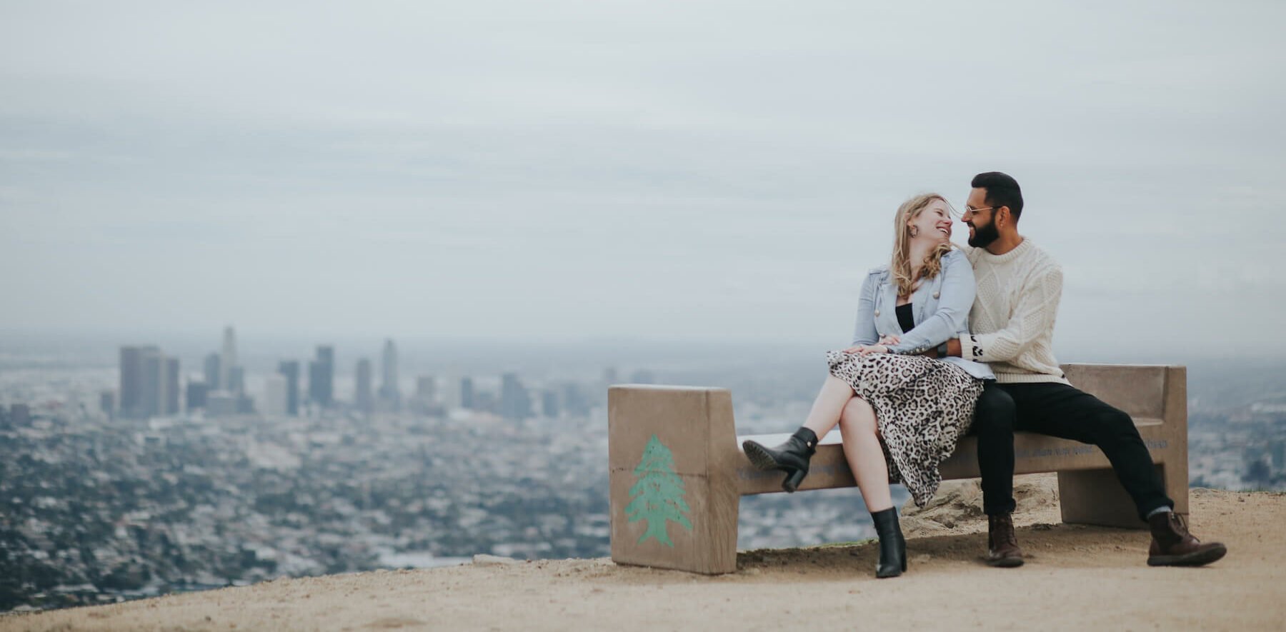 couple sitting on bench overlooking downtown Los Angeles