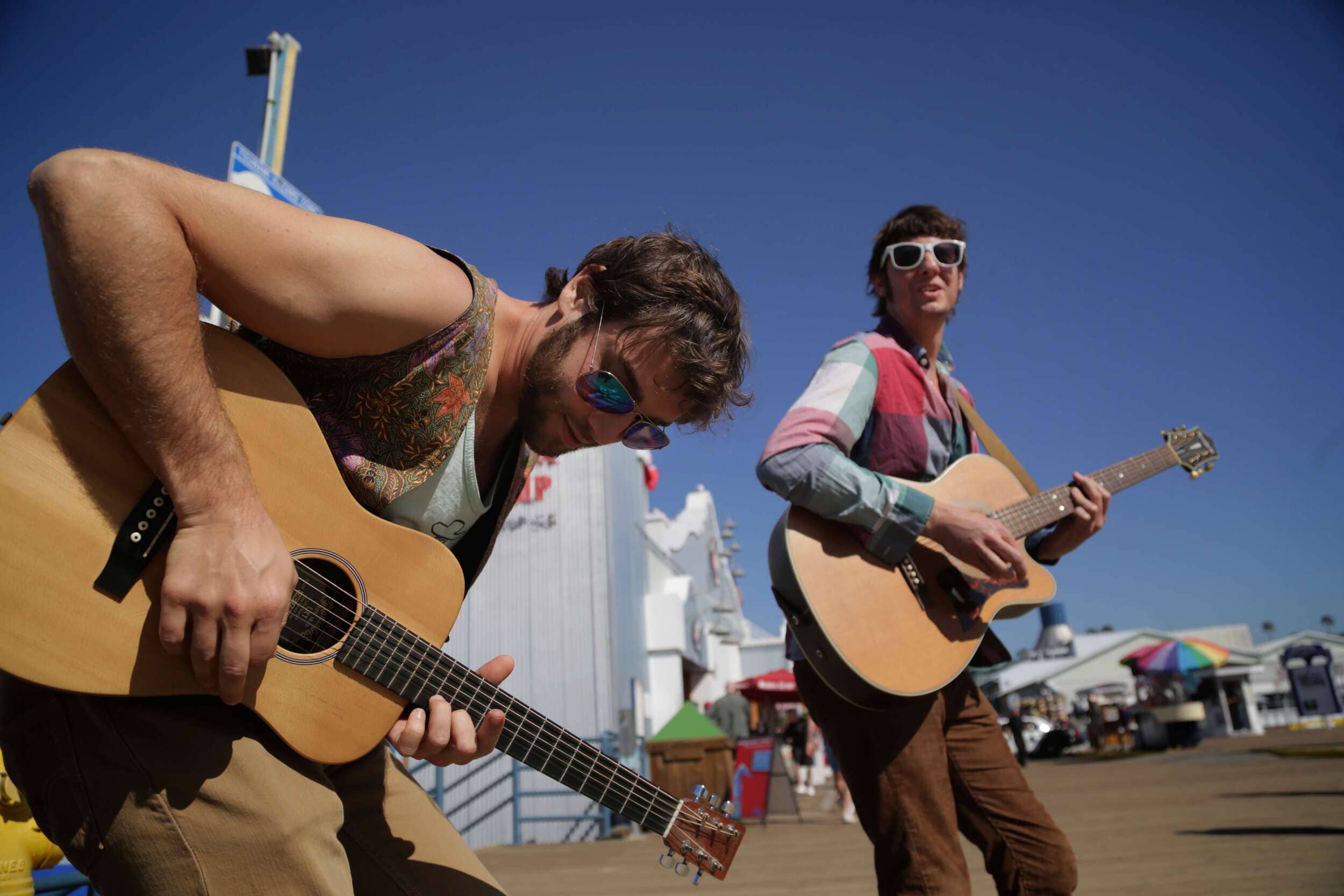 two people playing guitar outside