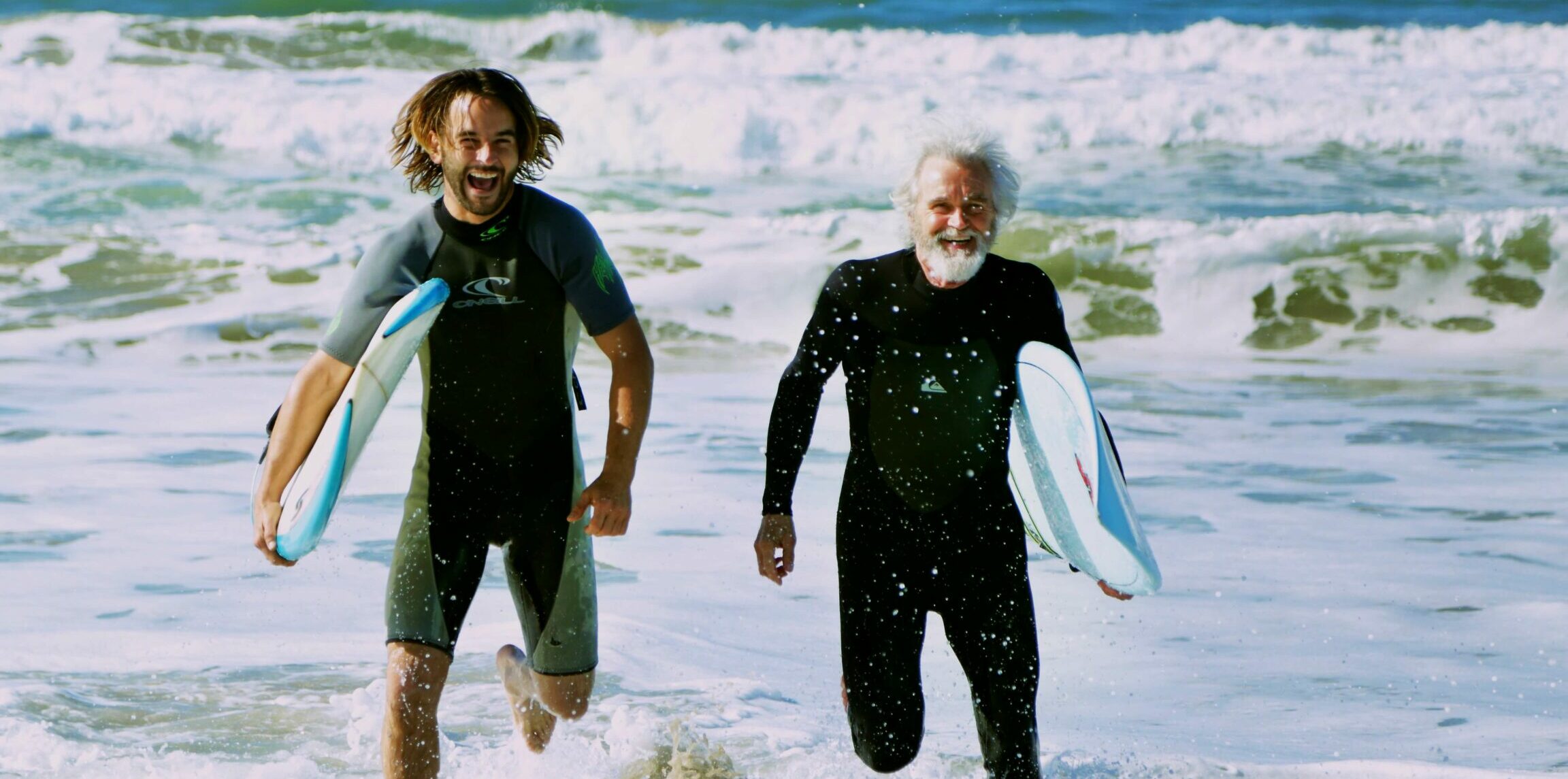 two surfers walking in the ocean