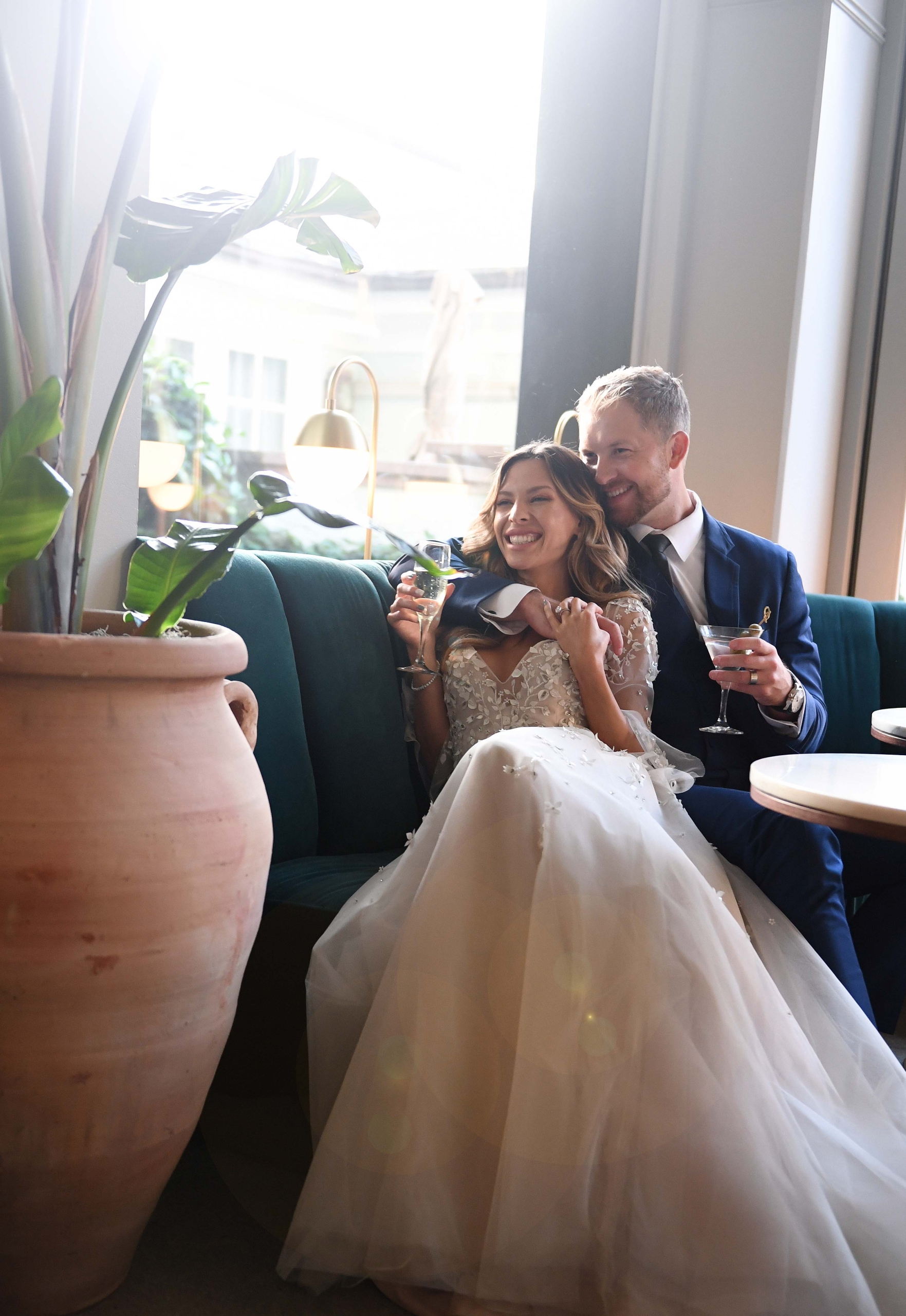 bride and grooming with champagne on a blue couch