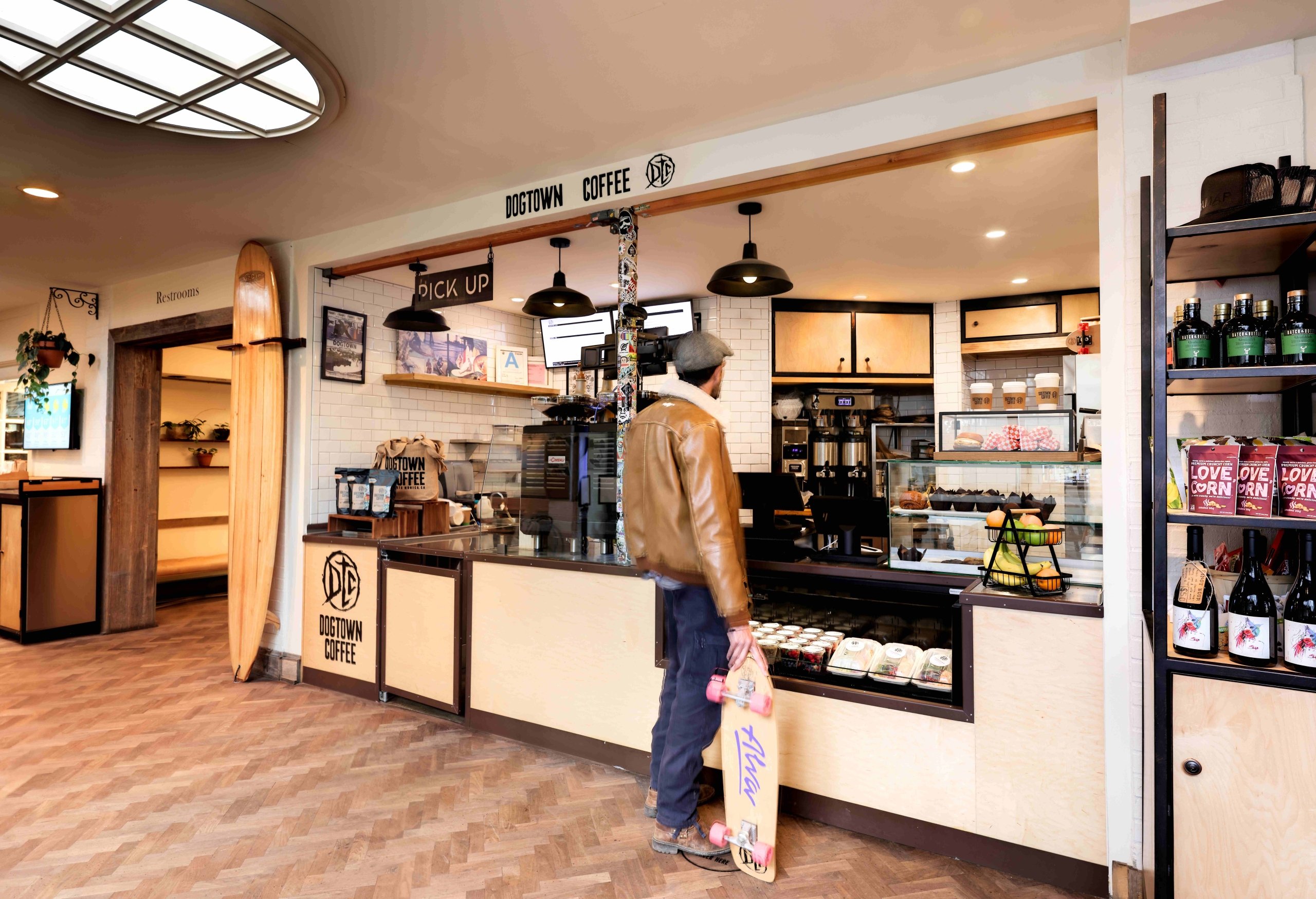 man with skateboard in front of a coffee shop