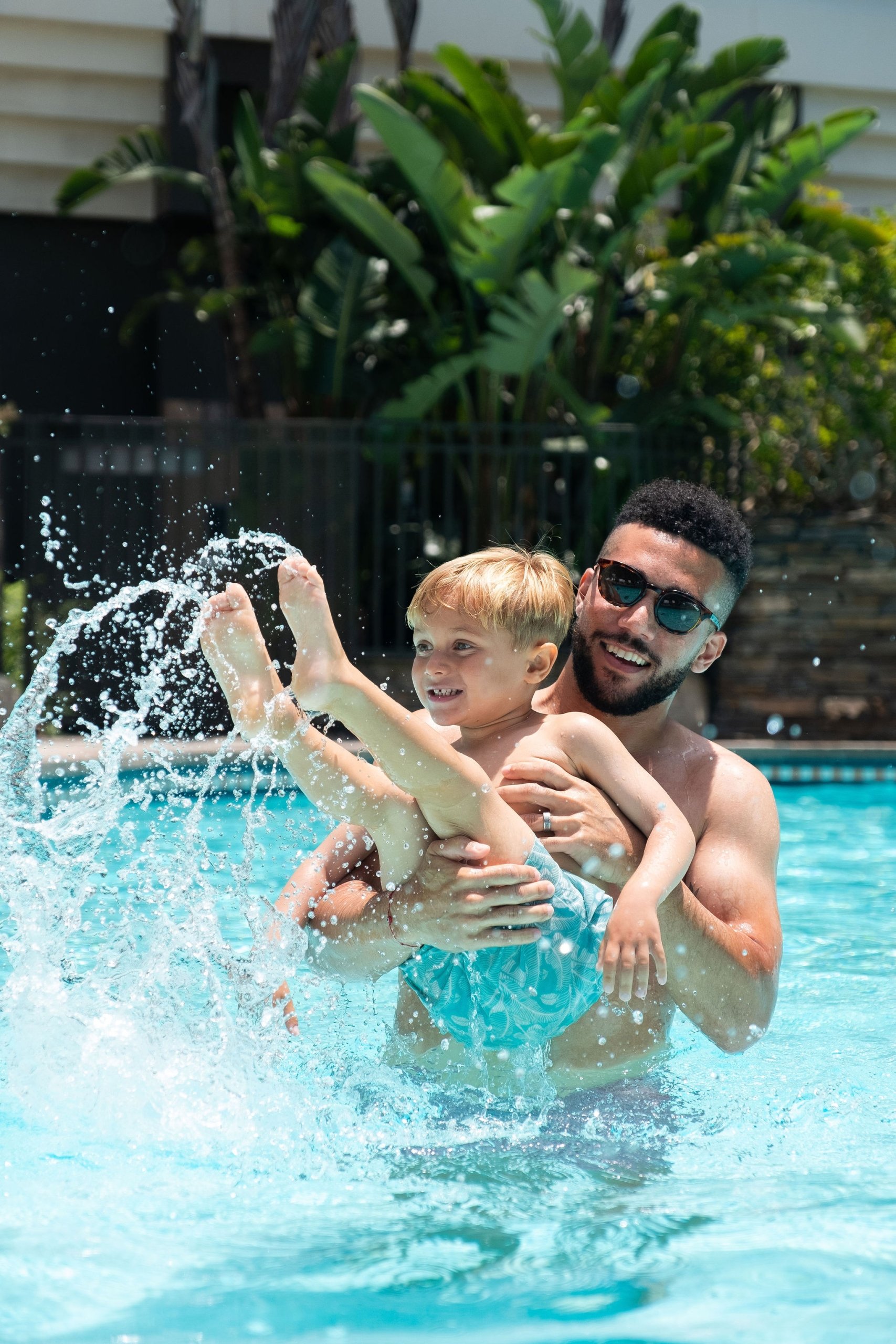 dad throwing a kid around in the pool