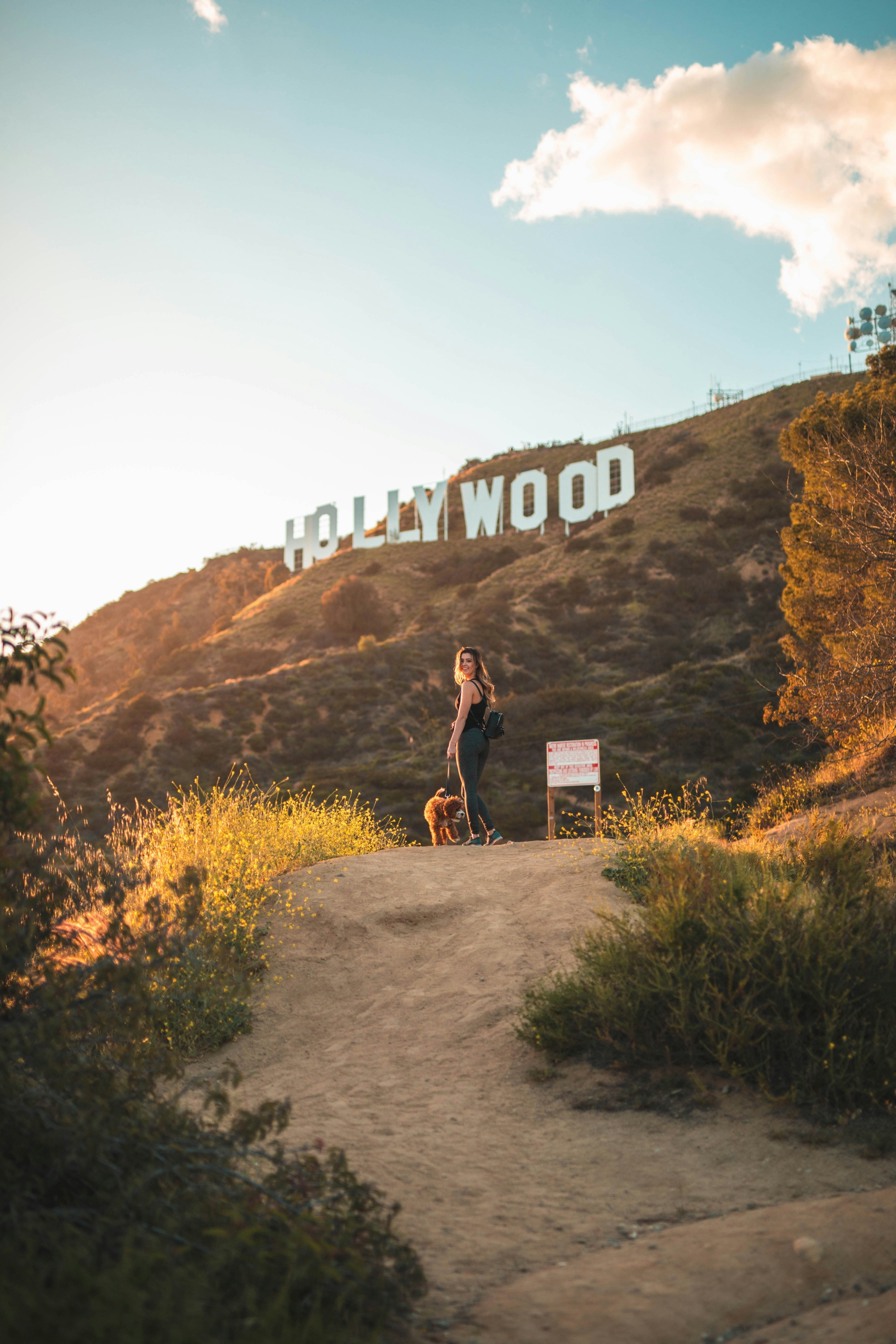 a woman walking towards the hollywood sign